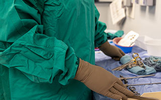 Gros plan d’un employé de l’hôpital portant une blouse chirurgicale écologique et réutilisable dans une salle d’opération du Campus Général