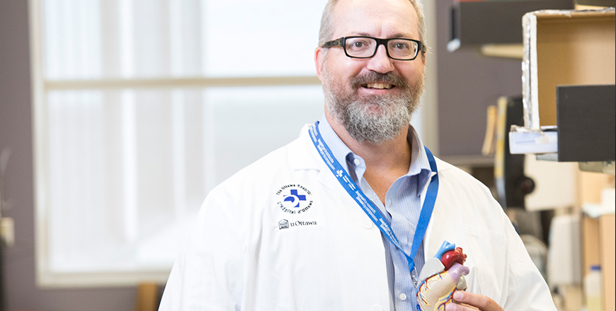 Senior scientist Dr. Lynn Megeney holds a heart model in his lab.